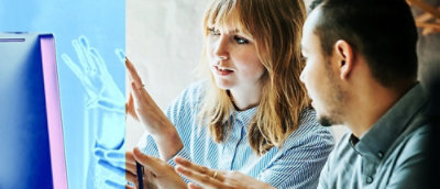 Colleagues collaborating while reviewing a screen.