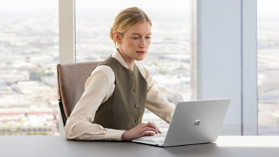 A person sitting at a desk using a laptop.