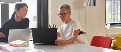 Two woman sitting in office environment and looking at the screen