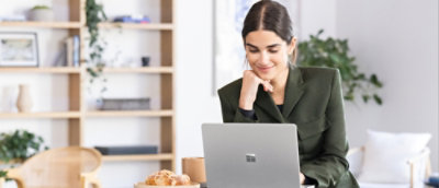A woman sitting at a table using a laptop.