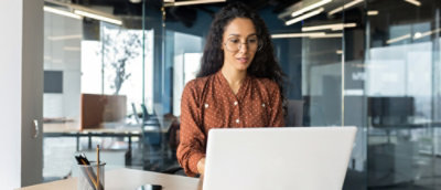 A women sitting in front of computer screen.