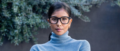 A portrait of a women wearing turtleneck t shirt and glasses.