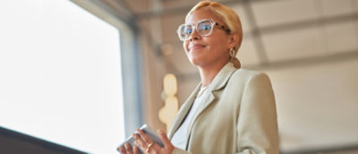 A woman holding a tab, smiling.