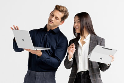 一位男士手持笔记本电脑，一位女士手持平板电脑。