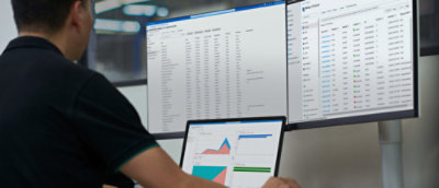 A person working in laptop and desktop.