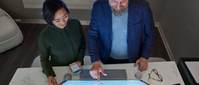 A man and women looking into a big screen.