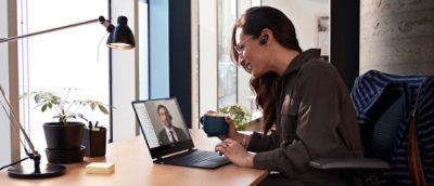 A women sitting in front of computer screen and talking in video call.