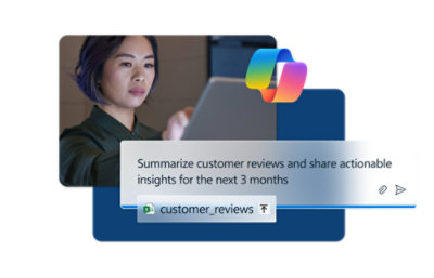 A woman sitting at a desk looking at a laptop.