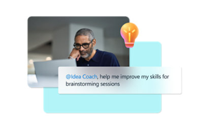 A man with glasses and a beard sitting at a desk under a sign that reads Idea Coach, help me improve my skills for brainstorming sessions.