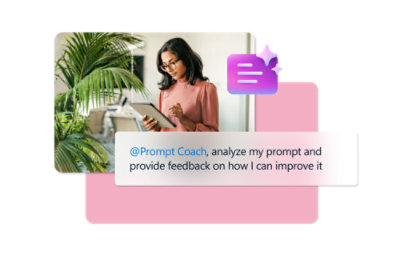 A woman in a pink shirt looking at a tablet next to a palm tree indoors.