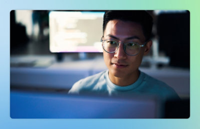 A person wearing glasses looking at a computer screen.