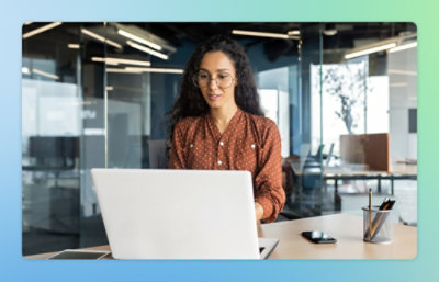 A person wearing glasses is using a laptop on a table.