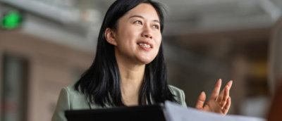 A women sitting at desk smiling and thinking.