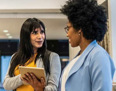 A women showing something on screen tab to a man.