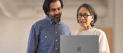 A women showing something on screen to a man