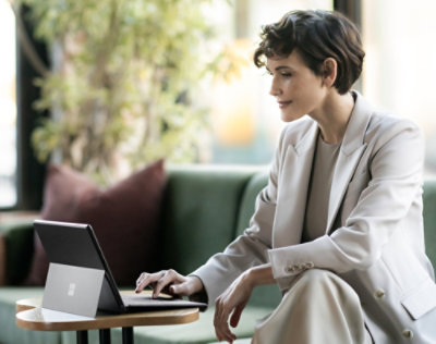 A women setting on chair and working with laptop.