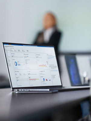 Laptop displaying an analytics dashboard on a desk during a presentation.