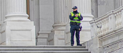 A security gaurd stand in front of building.