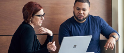 A man and woman looking at a laptop.