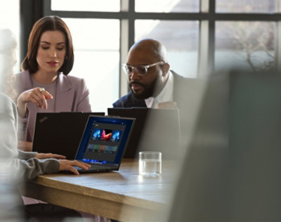 A group of people sitting at a table using laptops.