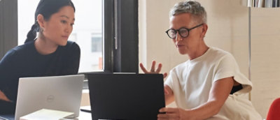 Sülearvutitega mees ja naine istuvad laua taga.