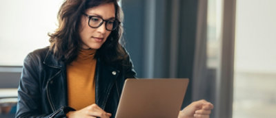 Prillidega inimene vaatab sülearvutisse.