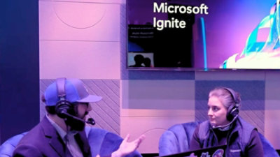 A woman and man sitting in chairs with microphones