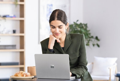 Person working on a laptop at a table with coffee.