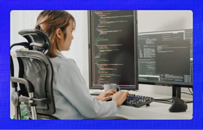 A woman sitting at a desk working on a computer.