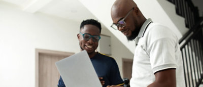 Two people are talking and discussing while looking at the laptop