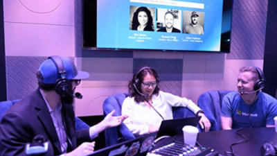 A woman and two men sitting in chairs.