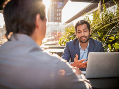 A man in a suit talking to another man.