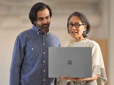A man and woman looking at a laptop.