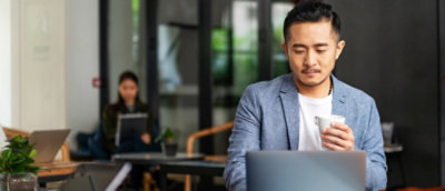 A man in a suit sitting at a laptop.
