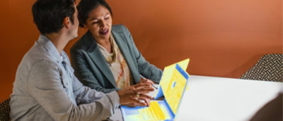 Two people discussing work on a laptop
