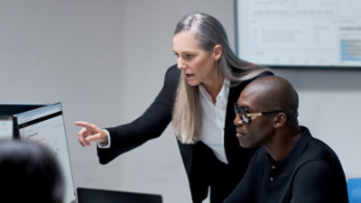 Two people reviewing content on a computer screen