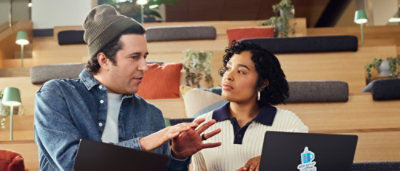 A man and a women discussing something using a laptop
