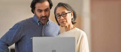 Zwei Personen, die auf einen Laptop schauen und diskutieren 