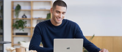 Man smiling and looking at the laptop screen