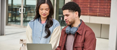 Two people looking at the screen and discussing