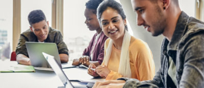 A group of people looking at a laptop
