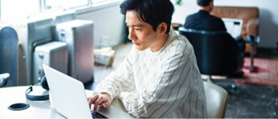 Osoba, která píše na přenosném počítači.