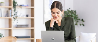 A person sitting at a desk looking at a laptop.