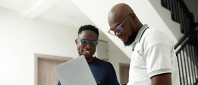 A man wearing a white shirt looking at a laptop.