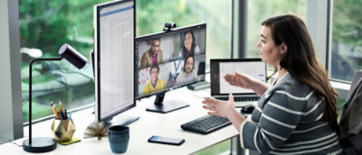A woman sitting in office environment and looking at the screen