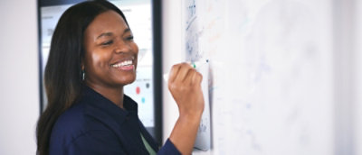 A close-up of a person writing on a whiteboard.