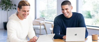 A couple of men looking at a laptop.