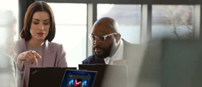 A man in glasses and a suit looking at a computer screen.