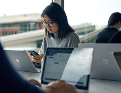 A women using her phone in office.