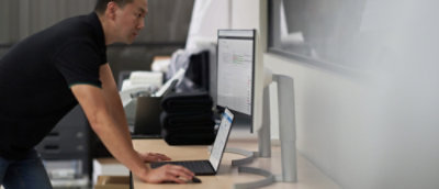 A man working on desktop and laptop.